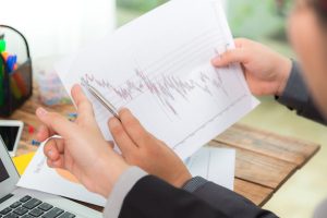 businessman looking paper with graphs